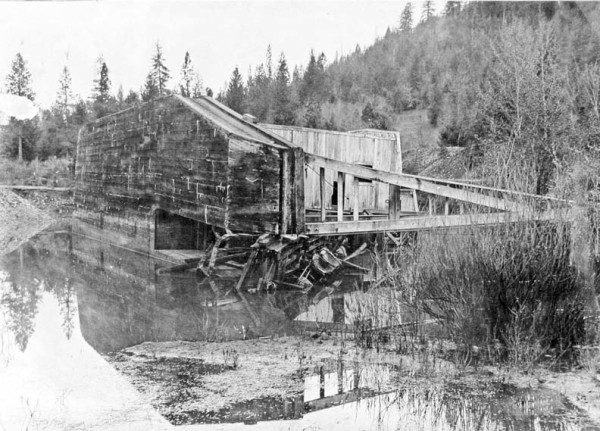 Photo showing the Josephine gold dredge on its side in a pond near Takilma, southwestern Oregon